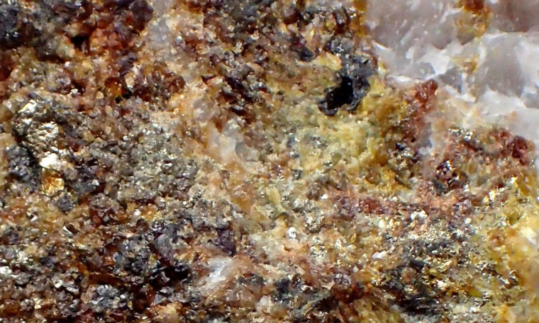 Närbild på mineralkorn i ett stenprov.