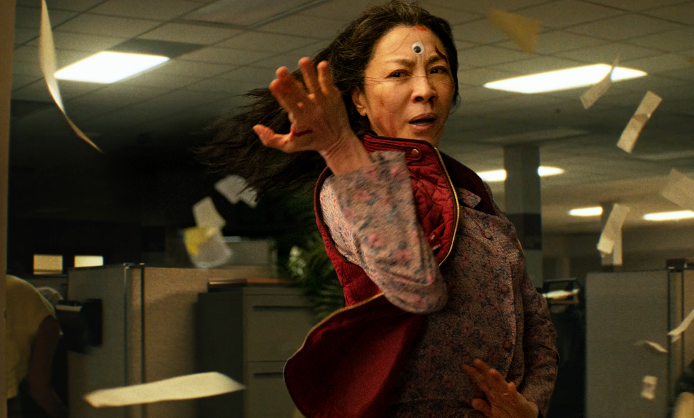 En asiatisk kvinna (Michelle Yeoh) i en kung fu-pose, med ett plastöga i pannan. Stillbild ur filmen Everything everywhere all at once.
