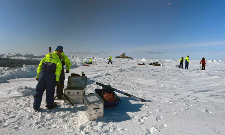 utristning och människor på is, i bakgrund isbrytare