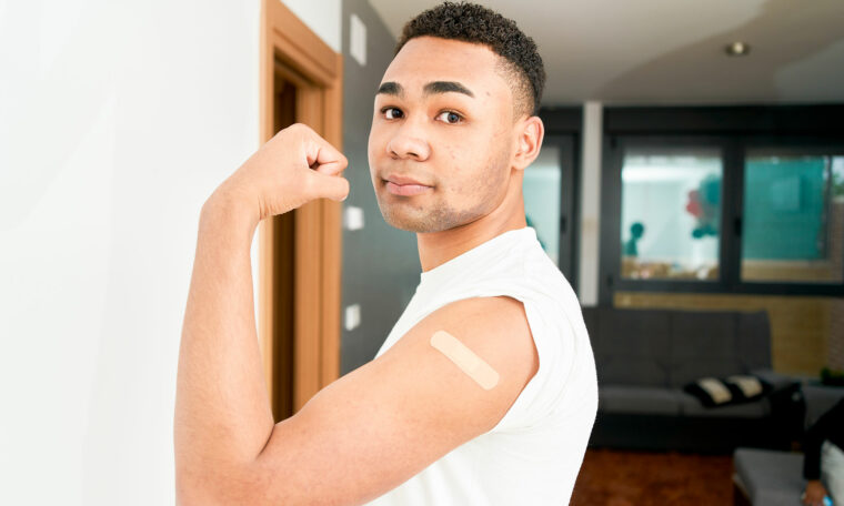 ung man visar upp arm med plåster efter spruta