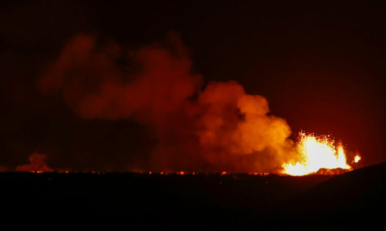 Lysande lava och rökmoln mot bakgrund av nattmörker.