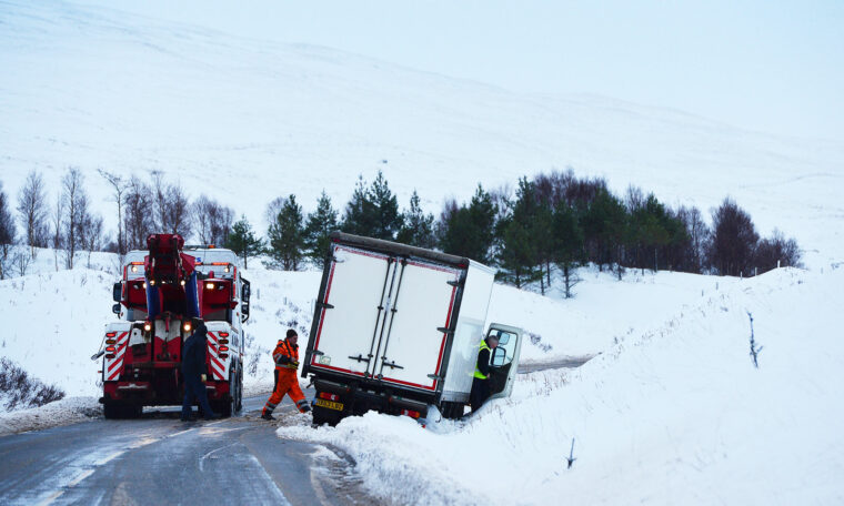 Lastbil har fastnat i snön, räddningsfordon på plats.