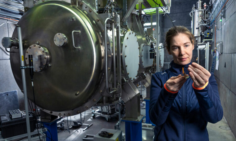 Rocio Santiago Kern framför kryostat i Freia-laboratoriet, där acceleratorkomponenter testas i superkyla.