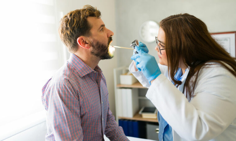 läkare undersöker mans hals