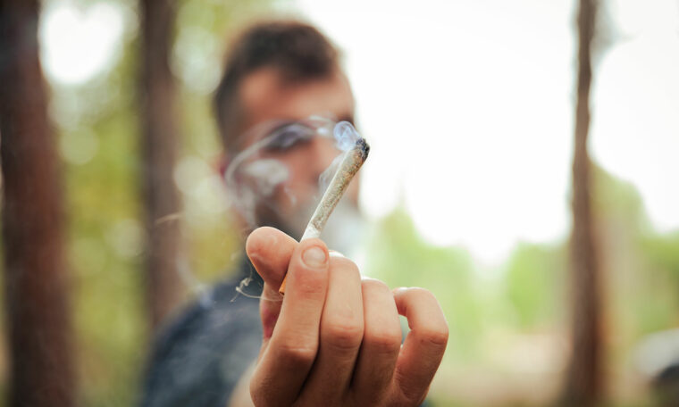 ung man räcker fram en joint