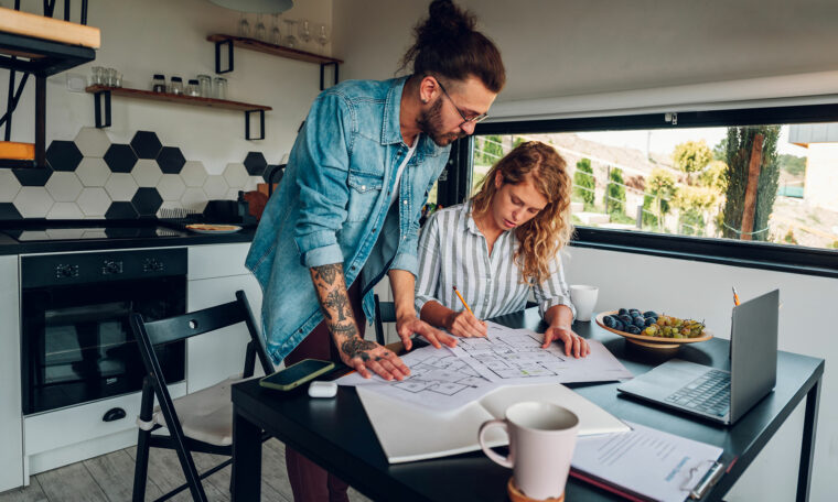 ungt par i kök ser på ritningar