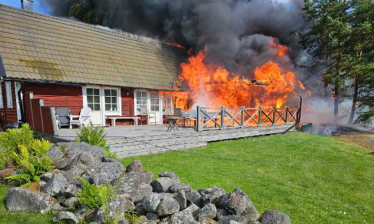 fullt utvecklad brand i rött hus med vita knutar