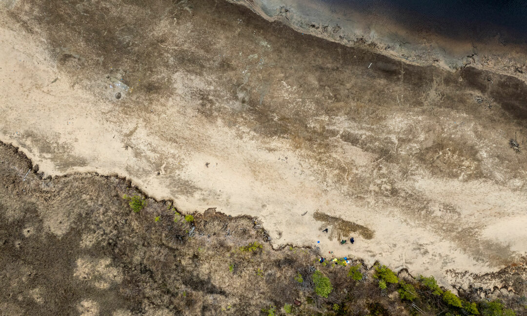 drönarbild på strand och älv