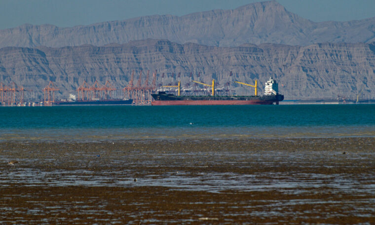 lastfartyg i lågvatten med berg i bakgrunden