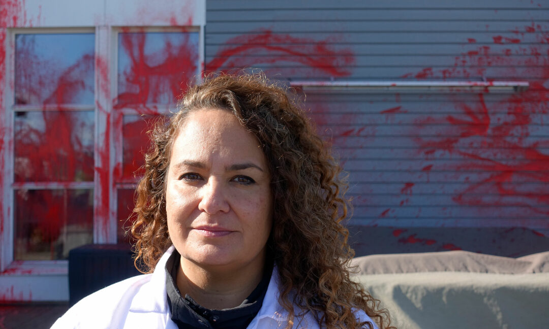 Esther Hauer framför vägg som sprutats röd