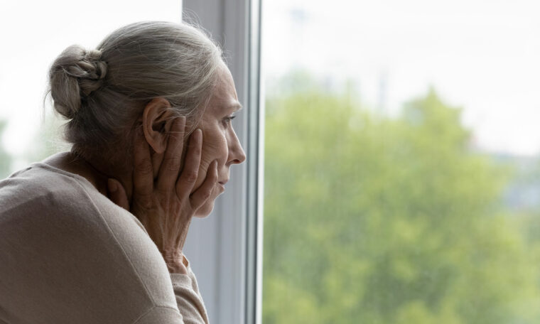 kvinna tittar ut genom fönster