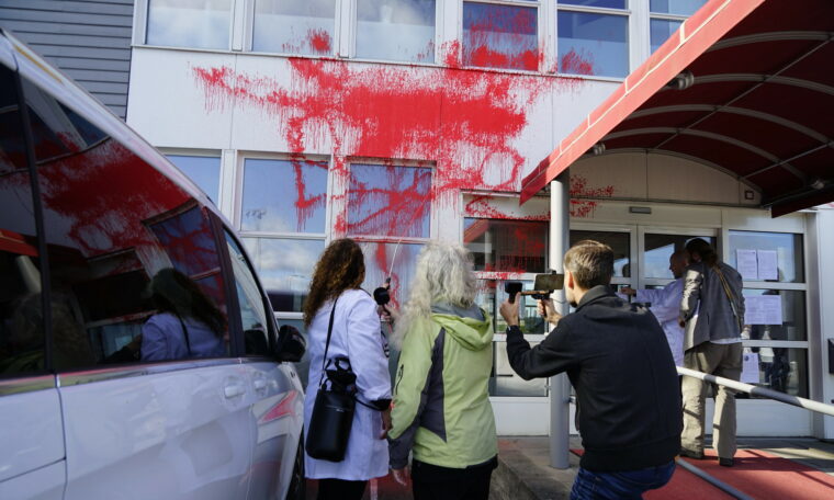 Aktivister sprutar rödfärg på terminalen vid Bromma flygplats.