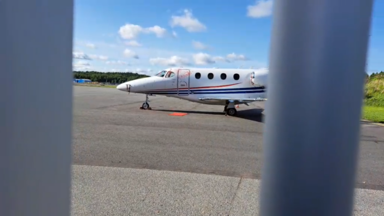 Röd färgfläck vid ett parkerat flygplan