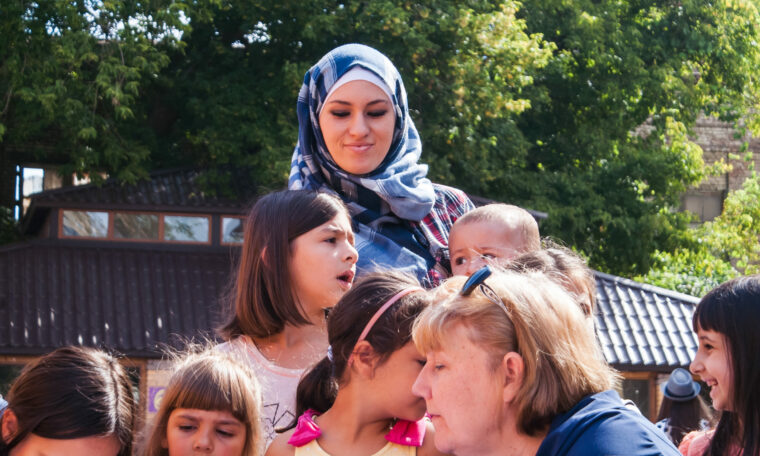 Kvinna som bär hijab tillsammans med flera barn.